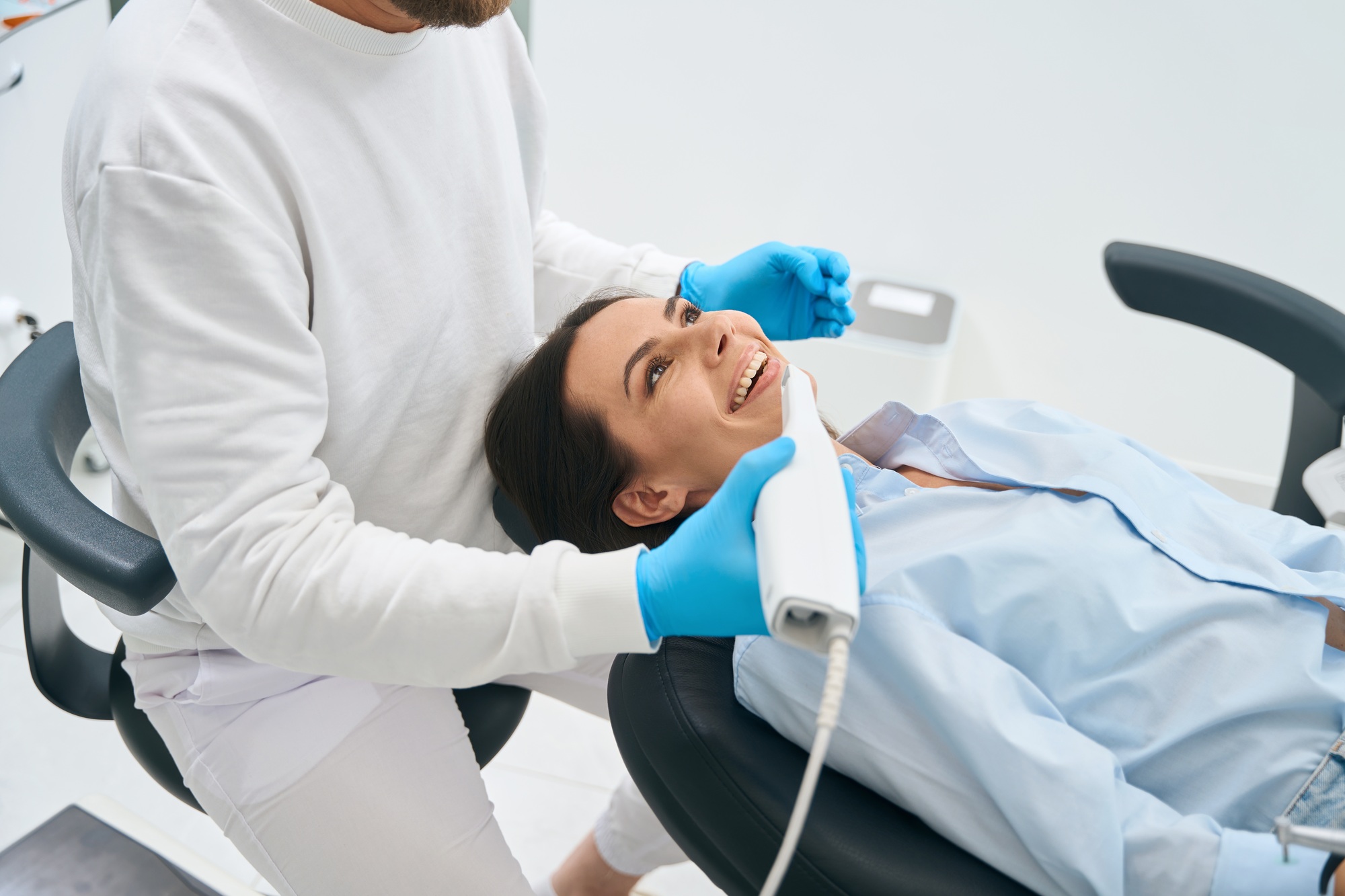 Dental technician holding intraoral camera for health screening